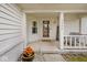 Covered porch area with welcome sign, outdoor seating, potted flowers, and a charming home entrance at 7347 Blue Creek S Dr, Indianapolis, IN 46256