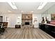 An expansive living room with wood flooring, a brick fireplace, and ample natural light from skylights at 7347 Blue Creek S Dr, Indianapolis, IN 46256