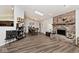 Bright living room with wood floors, a brick fireplace, skylights, and an open-concept design at 7347 Blue Creek S Dr, Indianapolis, IN 46256