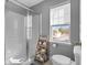 Bright bathroom featuring a glass door shower, wooden shelving and white toilet at 907 Junction Pl # 41907, Indianapolis, IN 46220