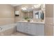 Bathroom featuring double vanity, soaking tub, shower and neutral earth tone tile at 907 Junction Pl # 41907, Indianapolis, IN 46220