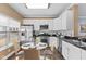 Eat-in kitchen features white cabinets, stainless steel appliances, and granite countertops at 907 Junction Pl # 41907, Indianapolis, IN 46220