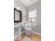 Powder room featuring pedestal sink, wood floors, and a framed mirror at 907 Junction Pl # 41907, Indianapolis, IN 46220