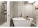 Bathroom featuring a gray walls, soaking tub with wood caddy, glass shower, and gray vinyl flooring at 9449 Maple Way, Indianapolis, IN 46268