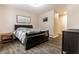 Bedroom with a black sleigh bed, wood nightstand, neutral bedding, warm lighting and wood floors at 9449 Maple Way, Indianapolis, IN 46268