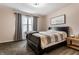 Comfortable bedroom featuring a black sleigh bed, neutral-toned bedding, warm light fixture and soft natural light at 9449 Maple Way, Indianapolis, IN 46268