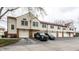 Townhome exterior featuring multiple garage doors and brick accents on a cloudy day at 9449 Maple Way, Indianapolis, IN 46268