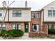 Charming townhome exterior with brick and siding, highlighted by a vibrant green front door at 9449 Maple Way, Indianapolis, IN 46268