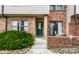 Inviting brick townhome facade with a bright green front door and an enclosed brick patio at 9449 Maple Way, Indianapolis, IN 46268