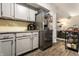 A bright kitchen includes stainless steel appliances, light-gray cabinets, warm wooden floors and granite countertops at 9449 Maple Way, Indianapolis, IN 46268