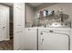 Laundry room with Maytag washer and dryer set with shelving, gray paint, and stairs in the background at 9449 Maple Way, Indianapolis, IN 46268