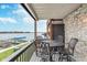 Charming balcony with stone accents, offering serene lake views and an iron table set for outdoor dining at 102 Clarendon Dr # 514, Noblesville, IN 46062