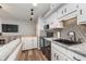 A modern kitchen features white cabinets, black appliances, and a decorative backsplash at 102 Clarendon Dr # 514, Noblesville, IN 46062