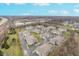Aerial view of townhomes near a lake with parking and green spaces under a blue sky with clouds at 1160 Falcon Rdg, Carmel, IN 46280