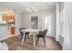 Bright dining area featuring hardwood floors, modern chandelier, and an adjacent kitchen at 1160 Falcon Rdg, Carmel, IN 46280
