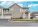 Townhouse exterior featuring neutral siding, a well-manicured lawn, and two-car garage at 1160 Falcon Rdg, Carmel, IN 46280