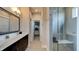 Elegant bathroom with double sinks, a walk-in closet, and a glass-enclosed shower at 13395 Vickery Ridge Dr, Fishers, IN 46037