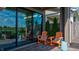 Covered patio featuring orange rocking chairs, a blue accent table, and modern sliding glass doors at 13395 Vickery Ridge Dr, Fishers, IN 46037