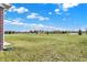 Brick exterior and large grassy field surrounded by trees and other houses under a clear blue sky at 1347 Shaw Ln, Shelbyville, IN 46176