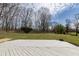 Spacious backyard featuring a wood deck and large green area surrounded by mature trees and landscaping at 1351 Sullivans Rdg, Zionsville, IN 46077