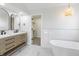 Elegant bathroom featuring double vanity, pendant lighting, soaking tub, and access to walk-in closet at 1351 Sullivans Rdg, Zionsville, IN 46077