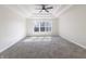 Spacious carpeted bedroom with tray ceiling, ceiling fan, and natural light through the windows at 1351 Sullivans Rdg, Zionsville, IN 46077
