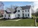 Charming two-story white home with a well-manicured lawn, complemented by a black roof and tasteful landscaping at 1351 Sullivans Rdg, Zionsville, IN 46077