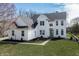 Stunning two-story white home featuring manicured landscaping, a gray roof, and charming architectural details at 1351 Sullivans Rdg, Zionsville, IN 46077