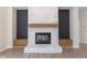Close-up of the fireplace featuring painted brick and dark wood accents in a light and airy living space at 1351 Sullivans Rdg, Zionsville, IN 46077