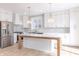 Elegant kitchen with white cabinetry, stainless steel appliances, a central island, and decorative backsplash at 1351 Sullivans Rdg, Zionsville, IN 46077