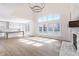 Open concept living room featuring a fireplace, large windows, hardwood floors, and seamless flow to the kitchen at 1351 Sullivans Rdg, Zionsville, IN 46077