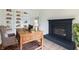 Cozy home office with a rustic desk, fireplace, and custom built-in shelving at 1351 Sullivans Rdg, Zionsville, IN 46077