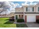 Charming townhome with a well-maintained lawn, attached garage, and inviting front porch with green door at 1568 Brookfield Cir, Franklin, IN 46131
