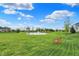 A red bench accentuates the lush, green lawn, offering peaceful pond views at 15752 Matthews Ln, Noblesville, IN 46060