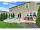 Stamped concrete patio is furnished with outdoor seating, and evergreens lining the lawn at 15752 Matthews Ln, Noblesville, IN 46060