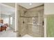 Modern tiled shower with glass door and convenient built-in shelving in a well-lit bathroom adjacent to a bedroom at 15752 Matthews Ln, Noblesville, IN 46060