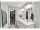 Modern bathroom with dual sinks, chrome fixtures, neutral tiling, and an open doorway to a well-organized walk-in closet at 15752 Matthews Ln, Noblesville, IN 46060