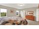 Bright bedroom boasts a warm wooden dresser and a large window overlooking the well-kept backyard, enhancing the room's appeal at 15752 Matthews Ln, Noblesville, IN 46060