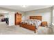 Well-lit bedroom featuring wooden furniture, large bed, carpeted floors, and views of a second living area, offering comfortable living at 15752 Matthews Ln, Noblesville, IN 46060