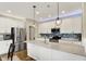 Bright modern kitchen features white cabinetry, stainless steel appliances, and an island with a quartz countertop at 15752 Matthews Ln, Noblesville, IN 46060