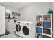 Bright laundry room features a washer, dryer, storage shelves and gray walls at 15752 Matthews Ln, Noblesville, IN 46060