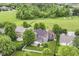 Beautiful aerial view of a private backyard with mature trees, a white fence, and solar panels on the roof at 15898 Bounds Dr, Noblesville, IN 46062