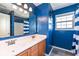 Bathroom with blue walls, double sinks, framed mirror and shower tub with curtain at 15898 Bounds Dr, Noblesville, IN 46062