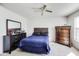 Bright bedroom featuring a ceiling fan, black furnishings and a tufted headboard bed at 1850 Blue Pine Ln, Indianapolis, IN 46231