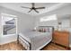 Cozy bedroom features a ceiling fan, natural light, wood floors and minimalist decor at 1945 Carrollton Ave, Indianapolis, IN 46202
