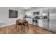 Modern kitchen with stainless steel appliances, white cabinetry, and dark countertops, alongside a wooden dining set at 1945 Carrollton Ave, Indianapolis, IN 46202