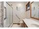 Bright bathroom features floral wallpaper, oak vanity, and walk-in shower with safety bar at 2054 Partridge Dr, Franklin, IN 46131