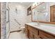 Bright bathroom features floral wallpaper, oak vanity, and walk-in shower with safety bar at 2054 Partridge Dr, Franklin, IN 46131