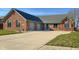 View of the all-brick single-story home with attached garage and basketball hoop on the driveway at 2054 Partridge Dr, Franklin, IN 46131
