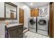 Bright laundry room featuring a sink with vanity, stacked washer, dryer, and cabinet storage at 2054 Partridge Dr, Franklin, IN 46131